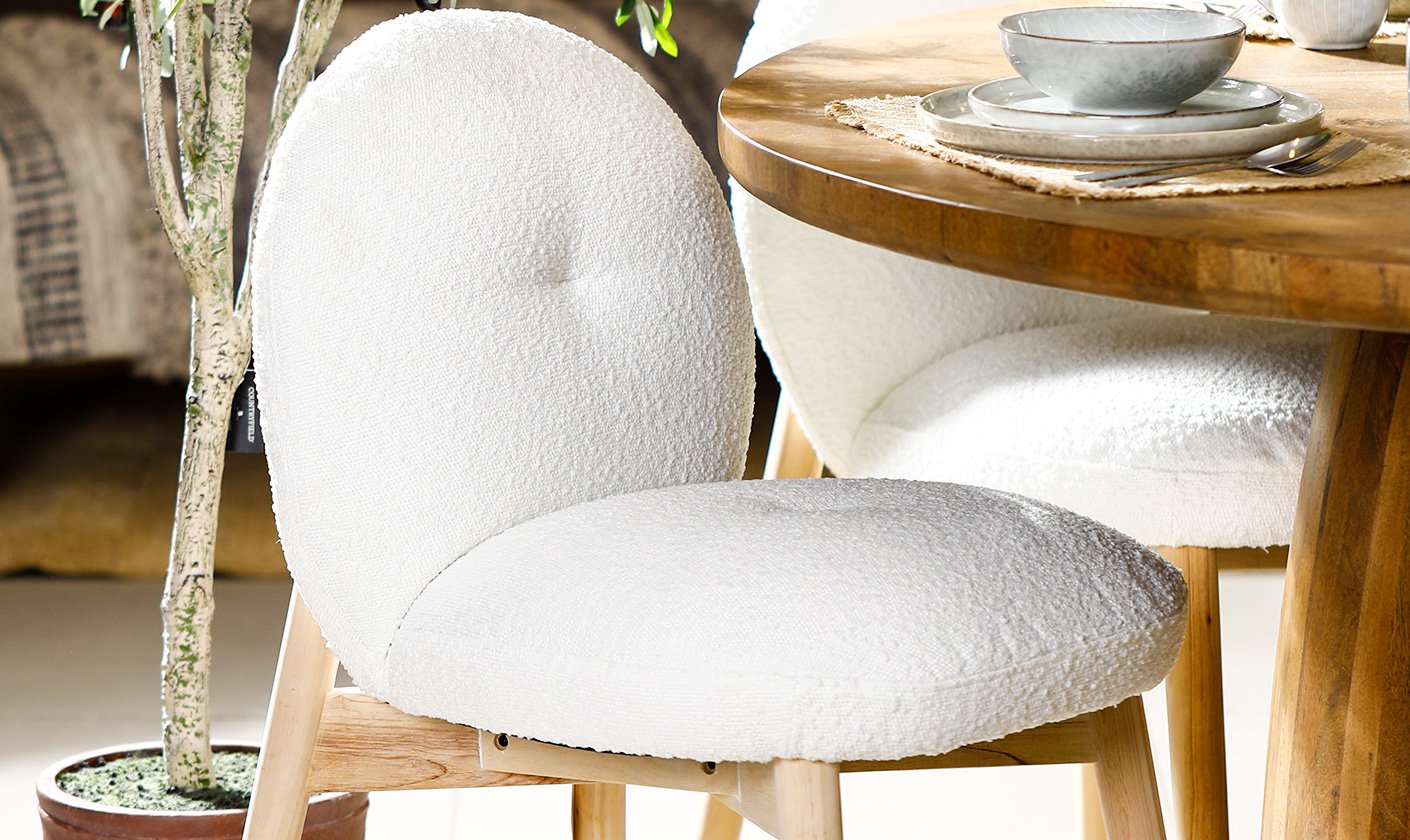 Modern white boucle dining chair paired with a wooden dining table, styled for contemporary interiors.